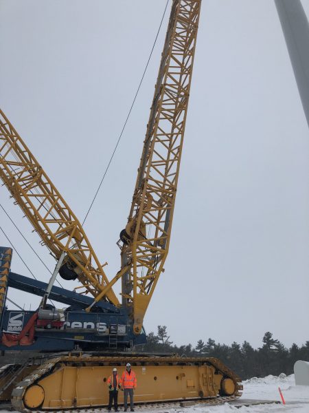 Workers installing a wind turbine at a wind farm site, contributing to the development of renewable energy infrastructure.