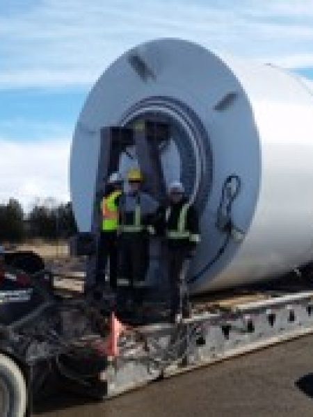 Technicians installing a wind turbine at a wind farm site, facilitating the development of renewable energy infrastructure.