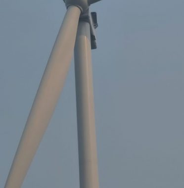 Technician performing rope access services for cleaning on a wind turbine tower, ensuring proper maintenance and inspection.
